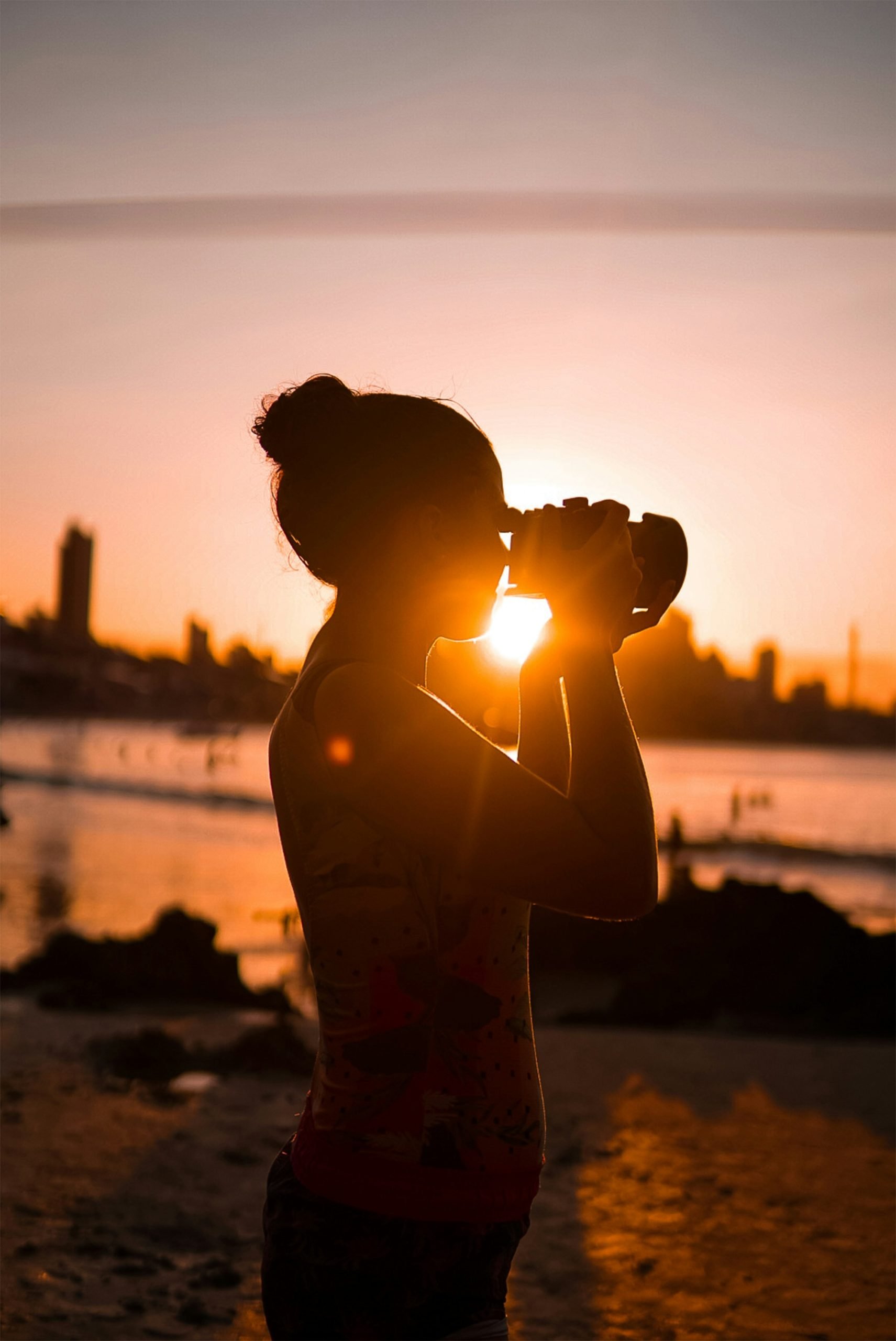 silhouette of man standing on beach during sunset